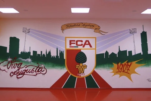 Das Logo des FCA hat die Form eines spanischen Schildes, die Buchstaben FC werden in den Vereinsfarben Rot, Grün, Weiß unterstrichen. Auf dem Augsburger Stadtwappen in Rot und Weiß wird eine grüne Zirbelnuss auf einem goldenen Sockel abgebildet, darunter befindet sich das Gründungsjahr des Vereins „1907“